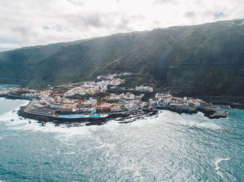 High angle view of sea and mountains against sky