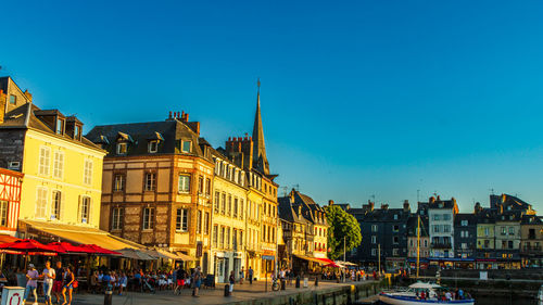 Illuminated buildings against clear blue sky