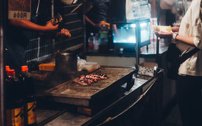 People standing by food in kitchen