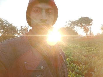 Portrait of man on field against bright sun