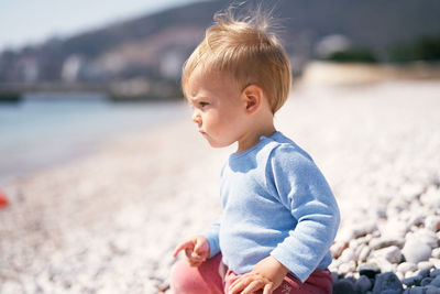 Full length of boy on pebbles at beach