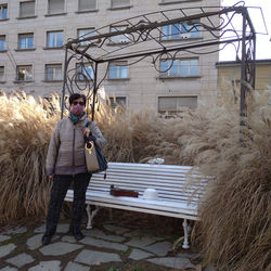 Full length of woman on seat in city