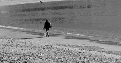 Rear view of man walking on beach