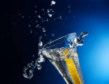 Close-up of water splashing on glass against black background