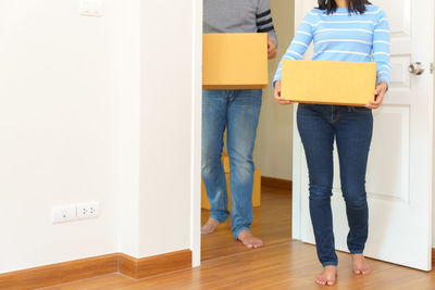 Low section of people standing on hardwood floor at home