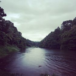 Scenic view of river against cloudy sky