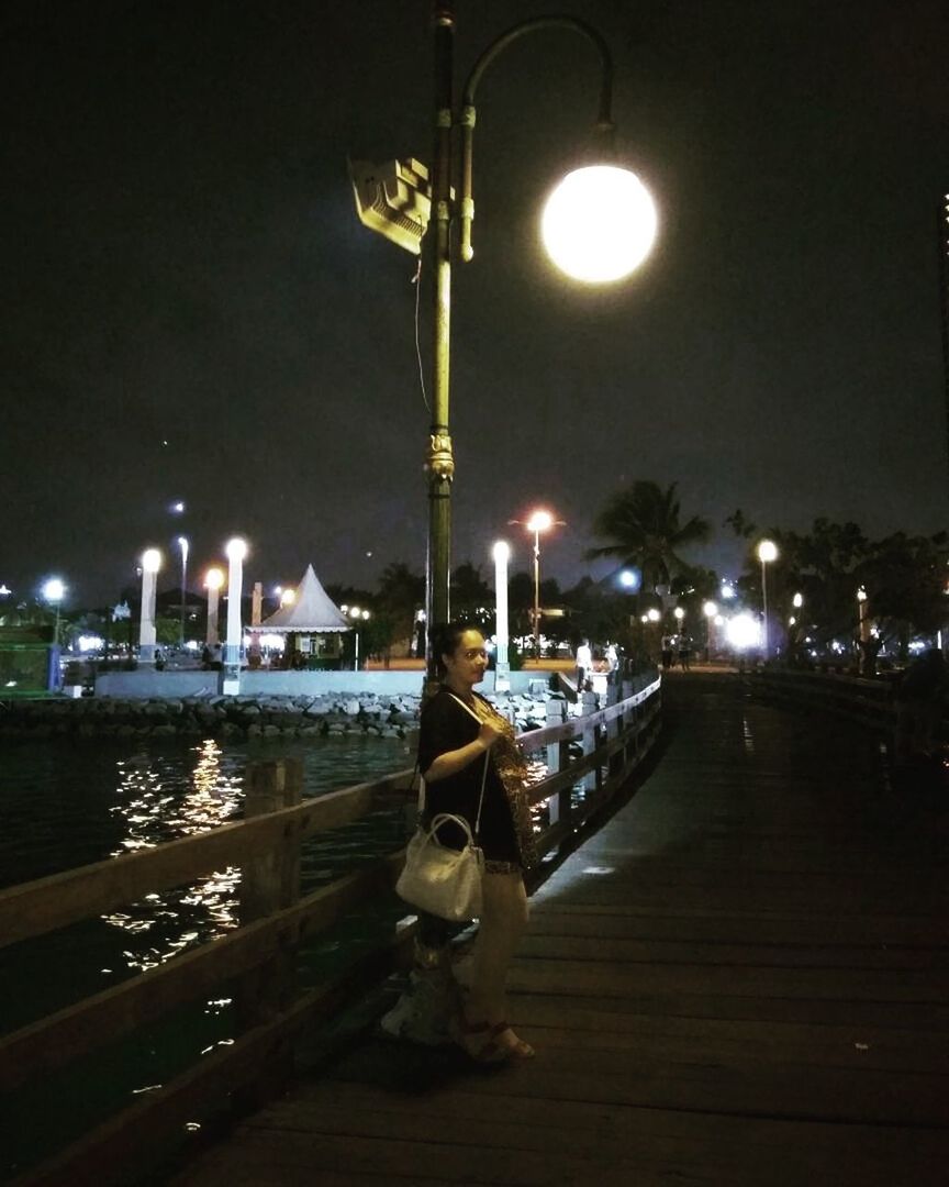 ILLUMINATED STREET LIGHT AGAINST SKY