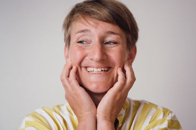 Portrait of smiling young man against white background