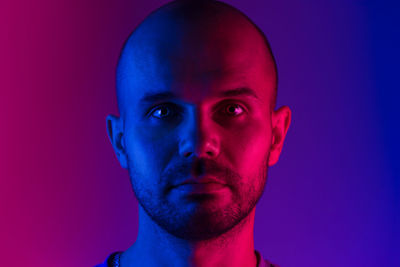 Close-up portrait of man standing in illuminated room