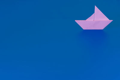 Low angle view of paper flag against blue sky
