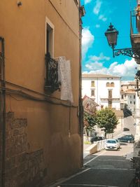 Street by buildings in town against sky