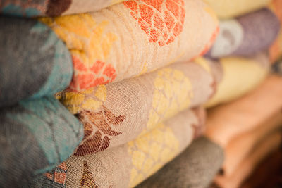 Samples of linen fabrics in a pile on store shelf.
