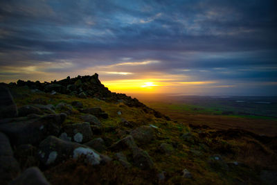 Scenic view of rocky landscape against sky during sunset
