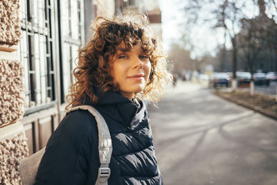 Portrait of smiling woman standing in city