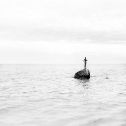 Man in sea against sky