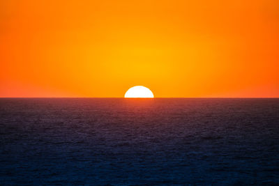 Scenic view of sea against orange sky