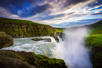 Scenic view of waterfall against sky