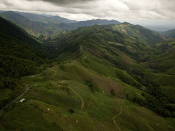 Aerial view of countryside road passing through the lush greenery tropical rain forest mountain