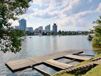 Scenic view of river by buildings against sky