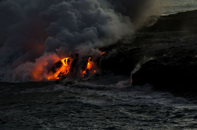 View of fiery lava flowing into ocean