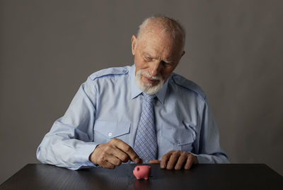 Man sitting on table against gray background