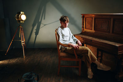 Full length of man sitting on chair at home