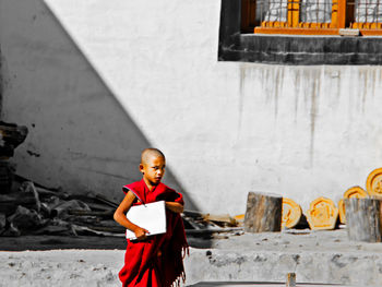 Portrait of boy standing against wall