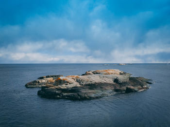 Rocks by sea against sky