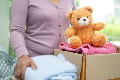 Midsection of woman with teddy bear