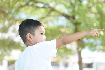 Portrait of cute boy with arms raised