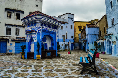 Empty chairs and buildings in city