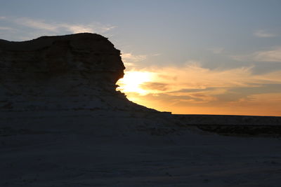 Scenic view of rock formation against sky during sunset