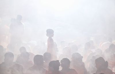 A girl standing inside croud in rakher upobash in a smokey environment at rakher upobash 