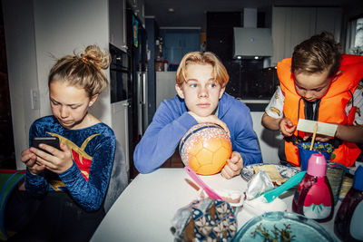 Male and female siblings sitting at table