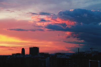 Buildings against dramatic sky during sunset