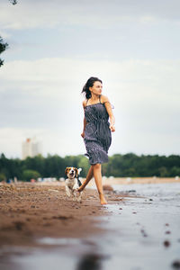 Full length of man standing on beach against sky