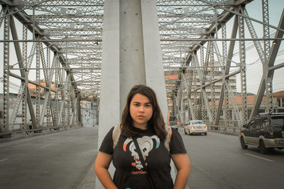 Portrait of young woman standing on city street