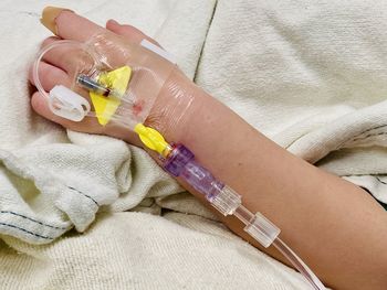 Cropped hand of patient with iv drip in hospital