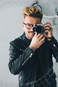 Portrait of smiling young man holding camera