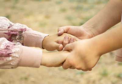 Midsection of couple holding hands