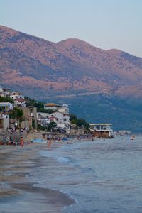 Scenic view of sea by town against sky