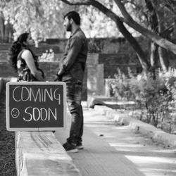 Indian couple posing for maternity baby shoot. the couple is posing in a lawn for baby shower shoot