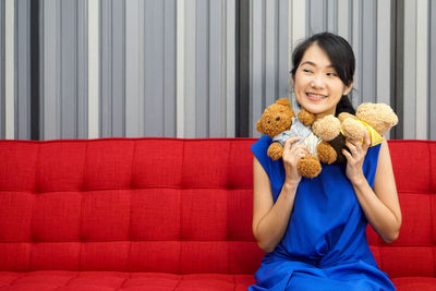 Portrait of a smiling young woman sitting on toy