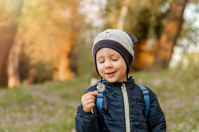 Boy looking away while standing in park during winter