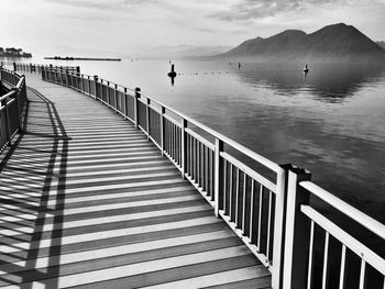 Boardwalk by river against sky