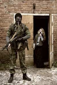 Army soldier holding rifle with civilian standing by door