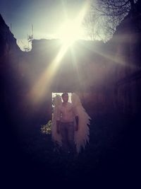 Young man wearing angel feathers in abandoned building