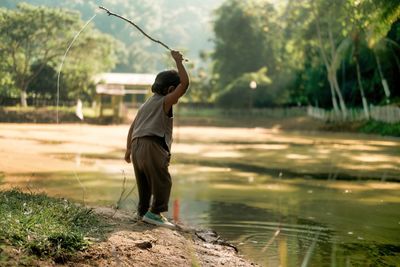 Rear view of woman standing in lake