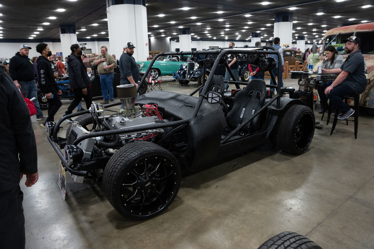 car, auto show, vehicle, transportation, mode of transportation, exhibition, group of people, race track, land vehicle, adult, automobile, indoors, shopping, men, sports car, sports, motor vehicle, crowd, wheel, large group of people, supercar, race car