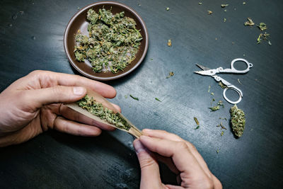 High angle view of hand holding food on table